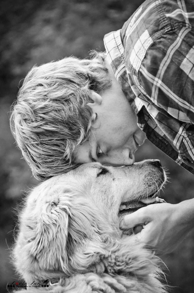 a person kissing a dog on the nose