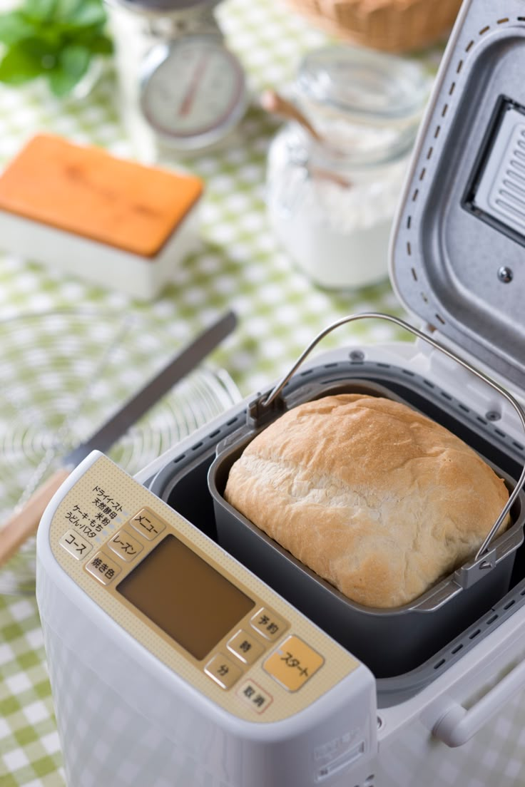 a loaf of bread sitting in an open container on top of a checkered table cloth