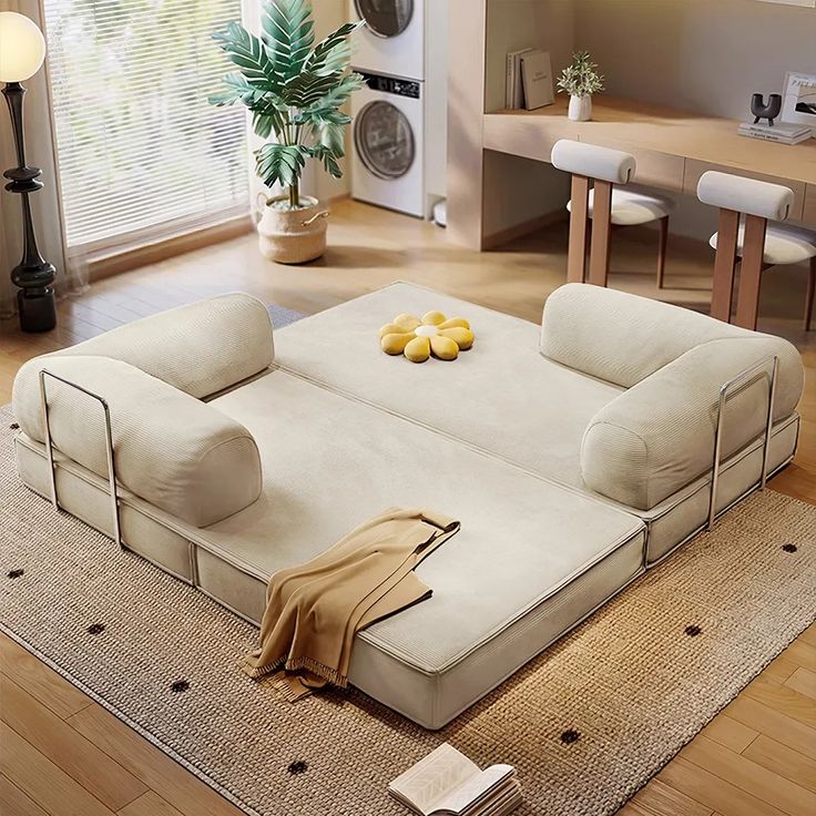 a living room filled with furniture on top of a hard wood floor covered in lots of pillows