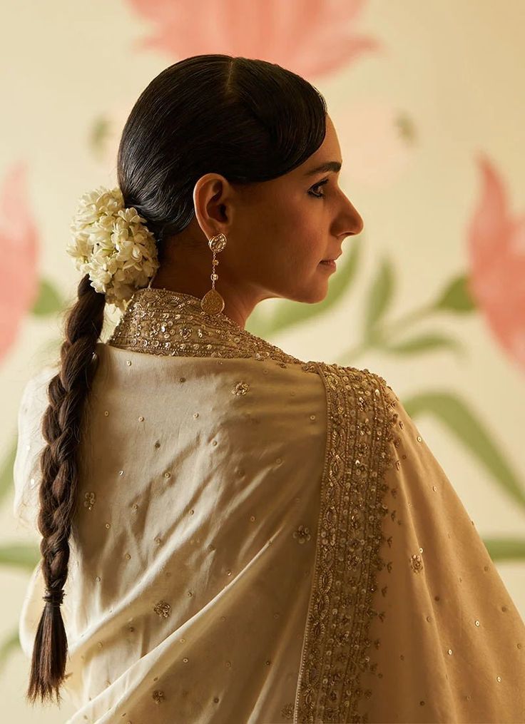 This beautiful ivory and gold Chanderi silk Kurta set exudes grace and elegance, featuring intricate embroidery adorned with sequins, pearls, and cutdana work. The anarkali top has a regal flair with delicate embellishments along the neckline, sleeves, and hemline, adding a luxurious touch to the traditional design. The flowy silhouette is paired with matching straight-cut trousers, offering both comfort and style. Completing the ensemble is a matching ivory dupatta embellished with gold embroid Designer Beige Salwar Kameez With Gota Work, Traditional Beige Kurta With Gota Work, Designer Cream Salwar Kameez With Gota Work, Cream Silk Anarkali Set, Unstitched Saree With Pearl Embroidery, Designer Traditional Draped Dupatta With Pearl Embroidery, Off White Silk Anarkali Set With Dupatta, Festive Georgette Dupatta With Pearl Embroidery, Beige Anarkali Set With Zari Work