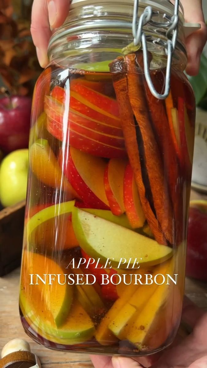 apples, carrots and other vegetables in a jar with the words apple pie infused bourbon