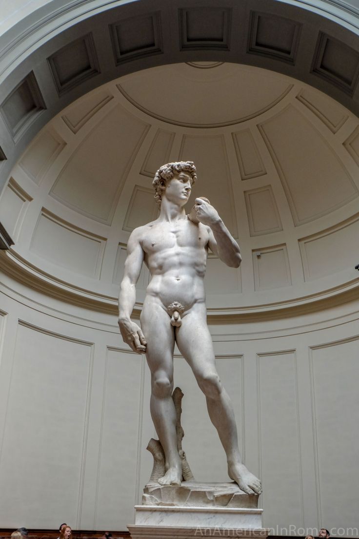 a statue of a man standing in front of a ceiling