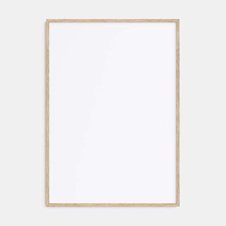 an empty wooden frame hanging on the wall with a white paper in front of it