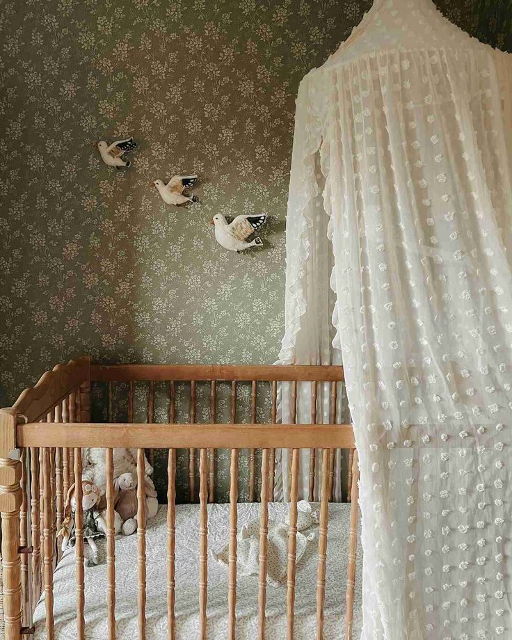 a baby crib with birds hanging on the wall