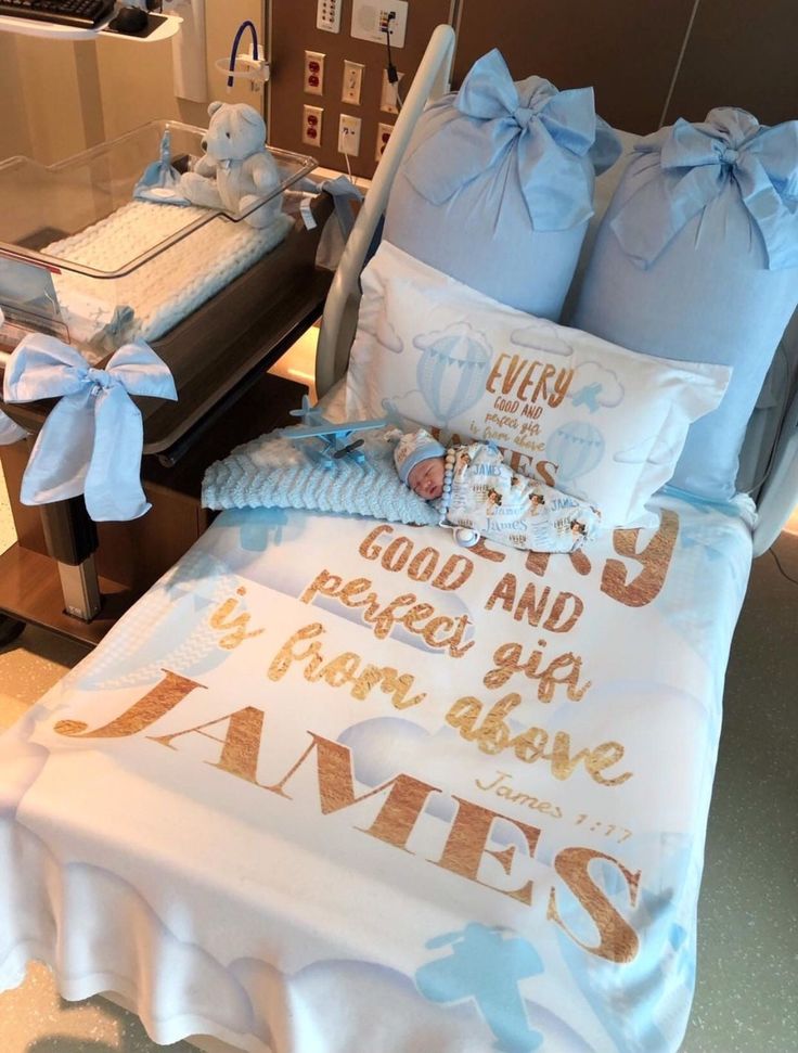 a bed with blue and white comforters on top of it next to a baby crib