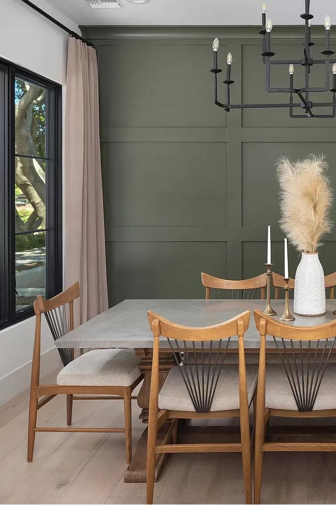 a dining room table with chairs and a vase on it