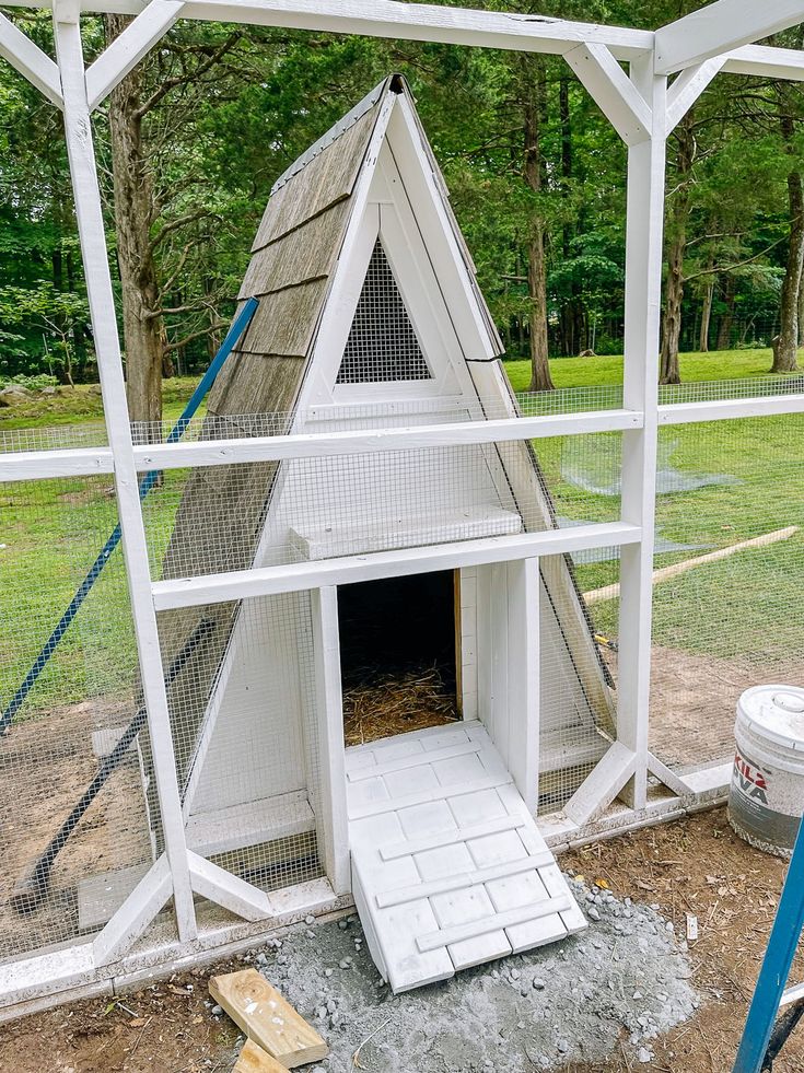 a chicken coop built into the side of a house with a ramp leading up to it