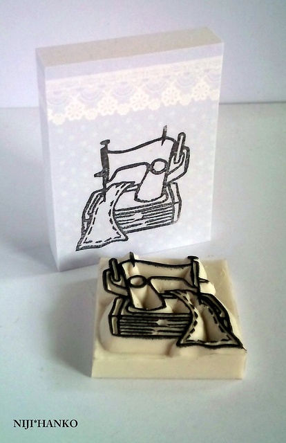 a rubber stamp with an image of a sewing machine on it's front and side