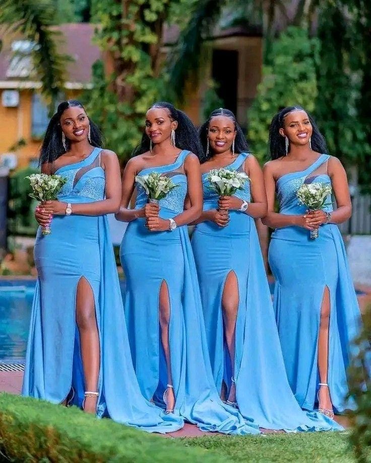 four beautiful women in blue dresses posing for the camera