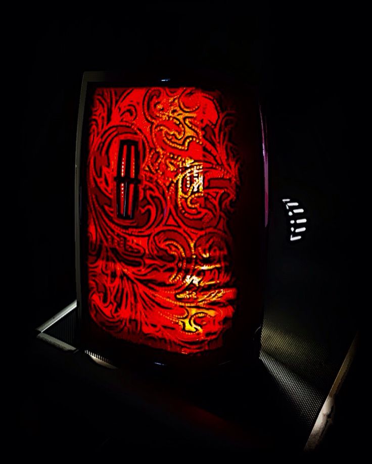 a red light in the dark with an intricate pattern on it's back side