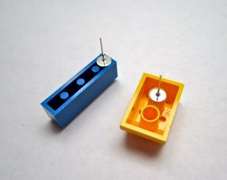 an orange and blue box sitting next to each other on a white surface with a clock in the middle