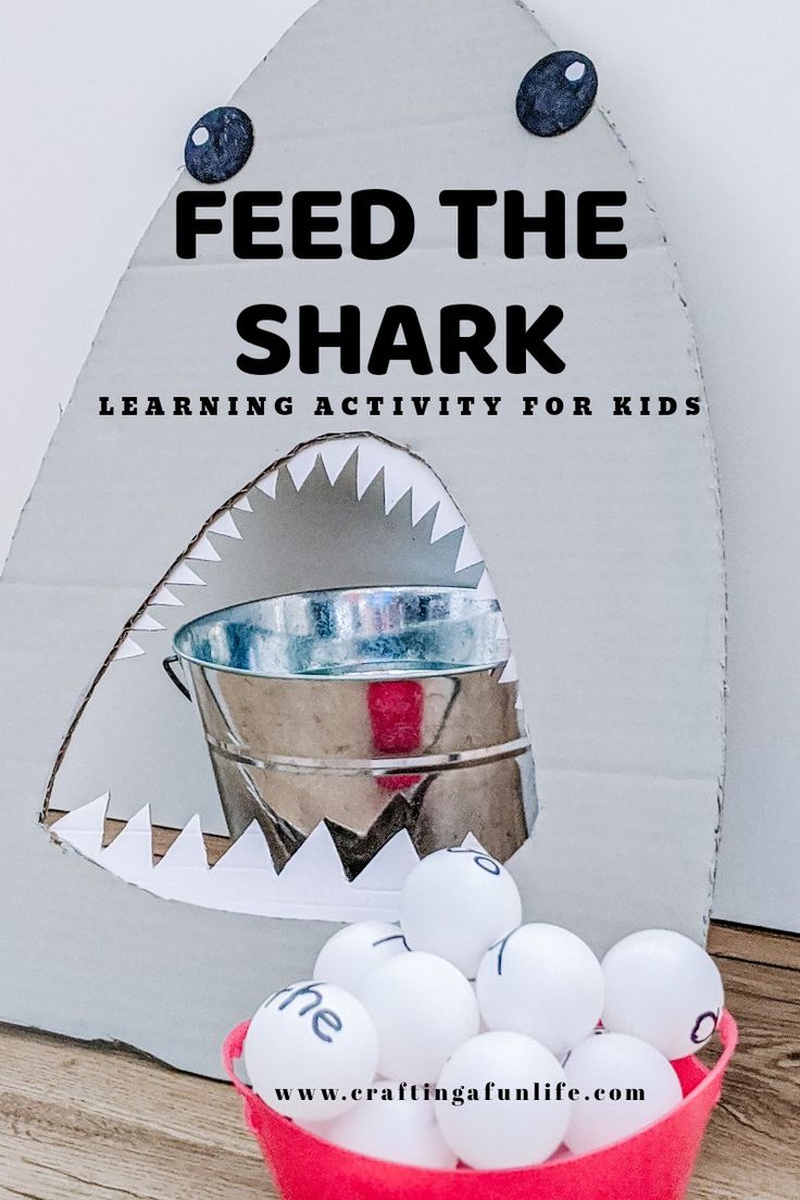 a red bucket filled with eggs sitting on top of a table next to a shark shaped sign