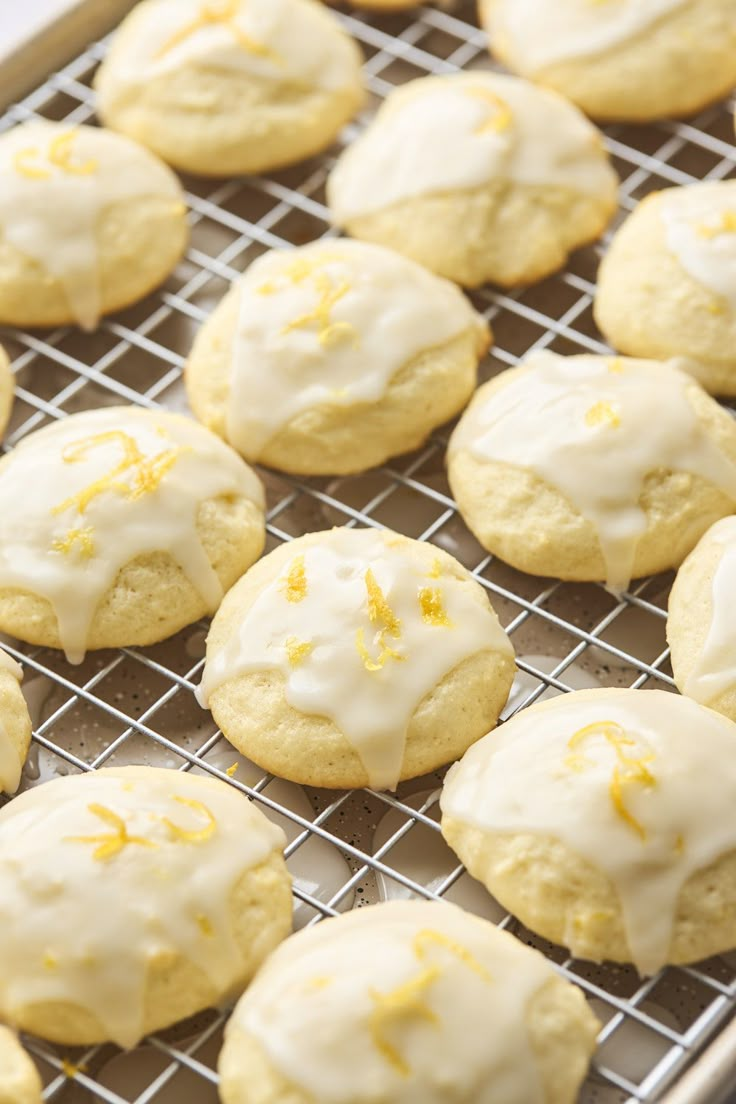 lemon cookies with white icing on a cooling rack, ready to be baked in the oven