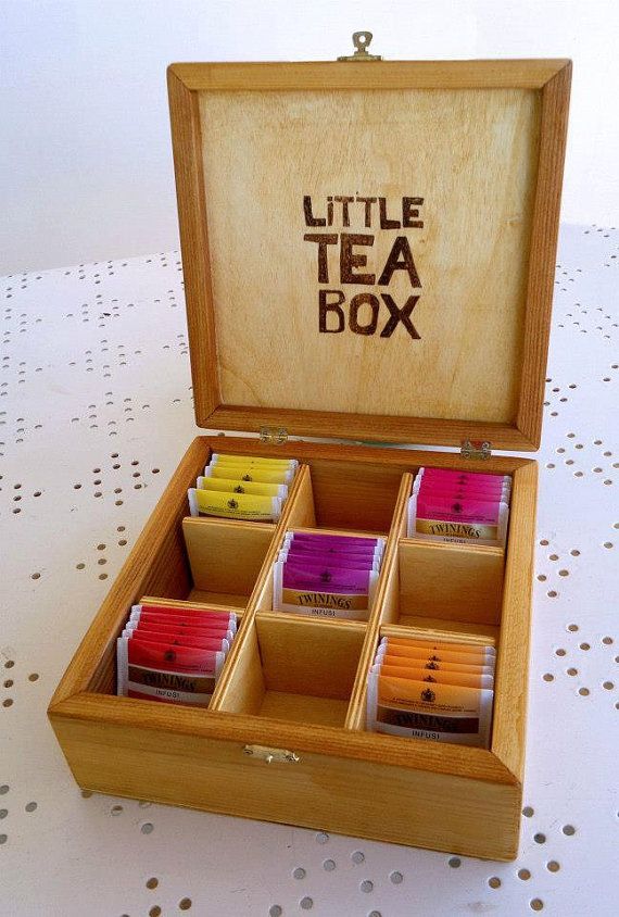 a wooden box filled with lots of different colored teas on top of a table