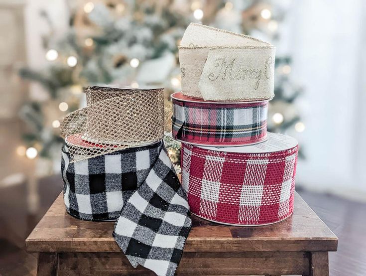 three plaid ribbon are stacked on top of each other in front of a christmas tree