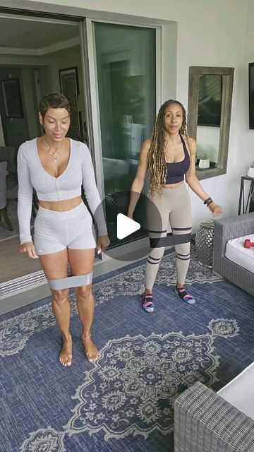 two women standing in front of a living room with sliding glass doors and blue carpet