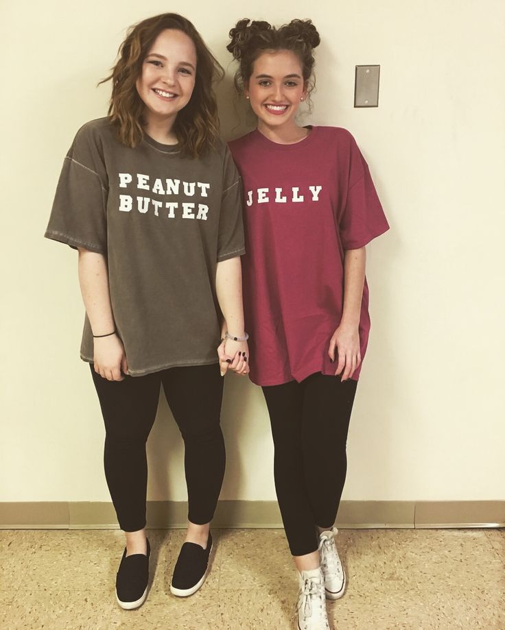 two women standing next to each other in front of a wall with peanut butter on it