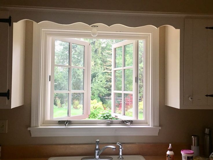 a kitchen sink sitting under a window next to a counter