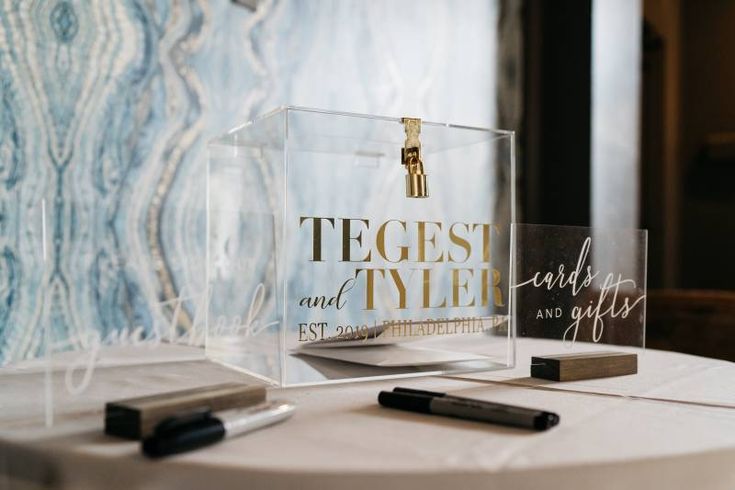 two clear acrylic signs sitting on top of a white tablecloth covered table