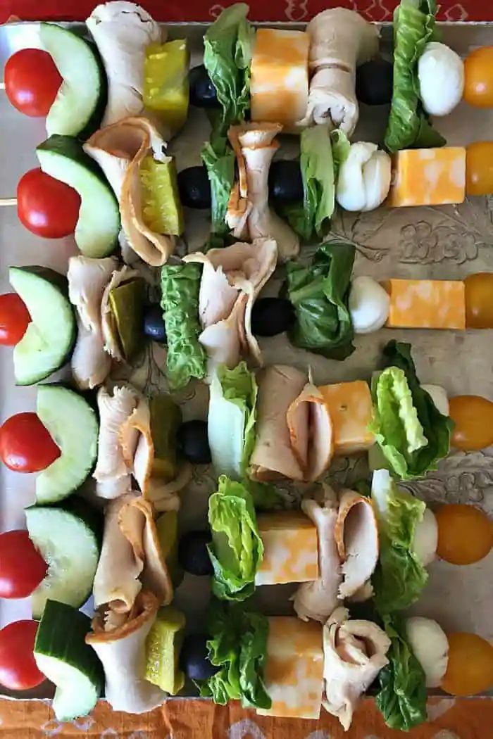 an assortment of vegetables and meat skewers on a platter, ready to be served