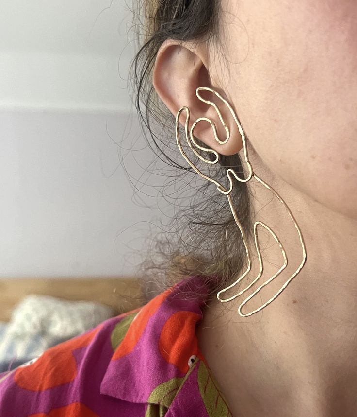 "This oversized, statement making, but still lightweight earrings are handmade by me. I \"drew\" them in 14k goldfilled wire, soldered together, polished, and soldered sterling posts to the shoulders. They flow with the jawline, and the hands are raised in celebration." Gold Artsy Earrings For Party, Artsy Gold Earrings For Party, Artsy Gold Wire Wrapped Earrings, Artsy Gold Earrings With Ear Wire, Artsy Gold Pierced Earrings, Artsy Gold Wire Wrapped Jewelry, Artsy Gold Earrings, Woman Outline, Lightweight Earrings