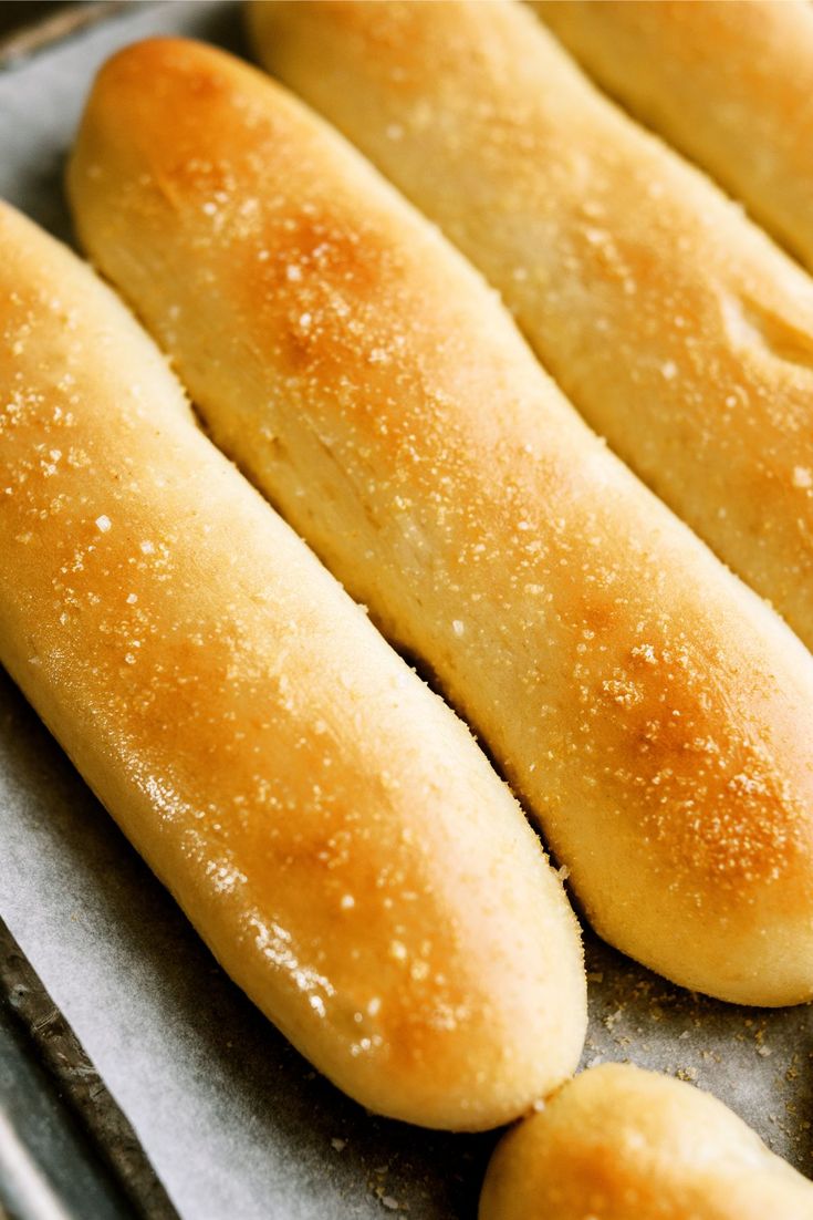 breadsticks are lined up on a baking sheet and ready to be baked in the oven