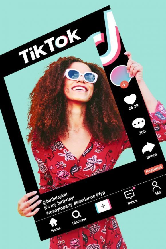 a woman wearing sunglasses holding up a photo frame with the word tiktok on it