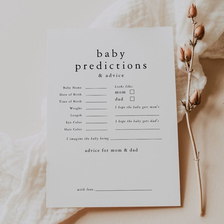 a baby dedication card sitting on top of a bed next to a dried flower and cotton swab