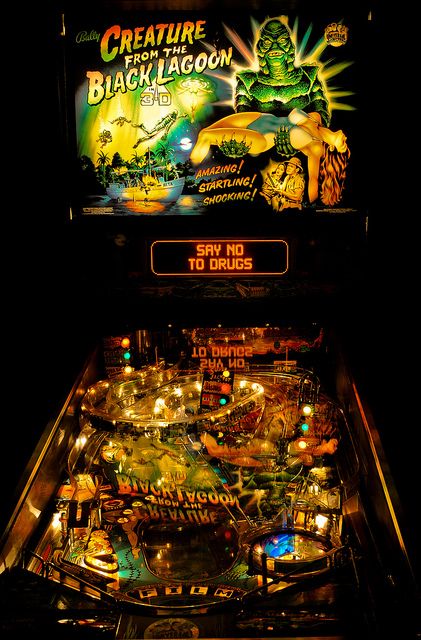 an old fashioned pinball machine with the game creature on it's display screen