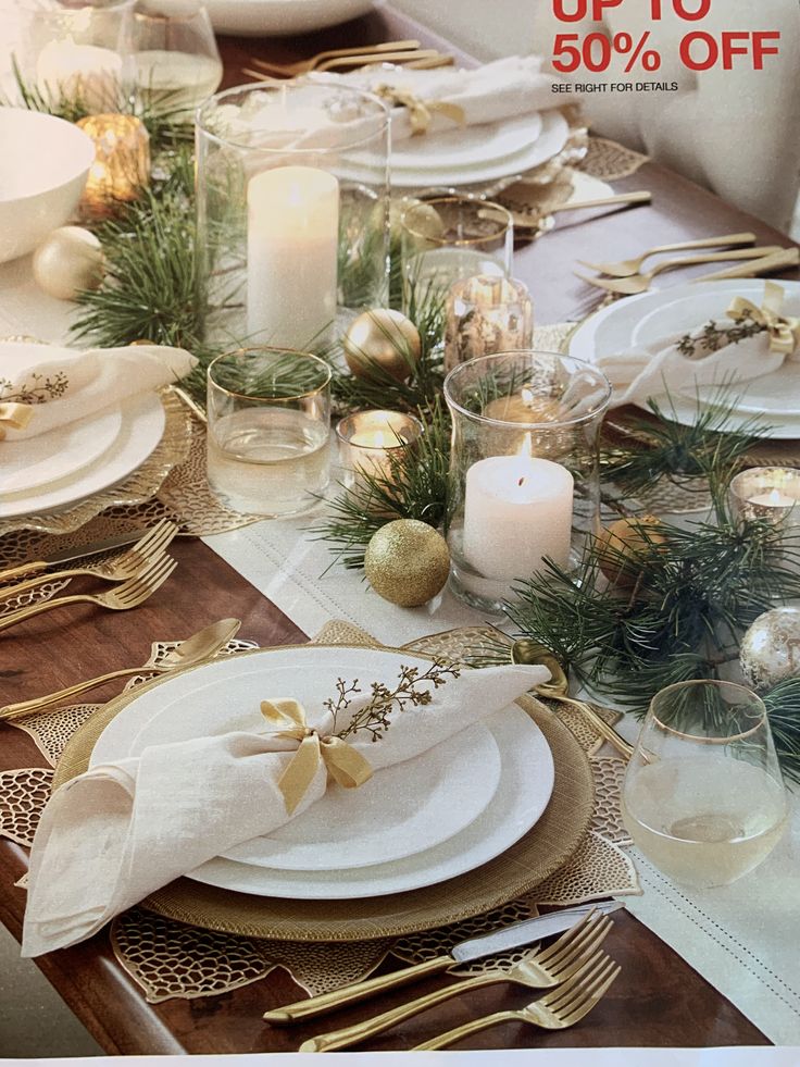 the table is set for christmas dinner with gold and white decorations