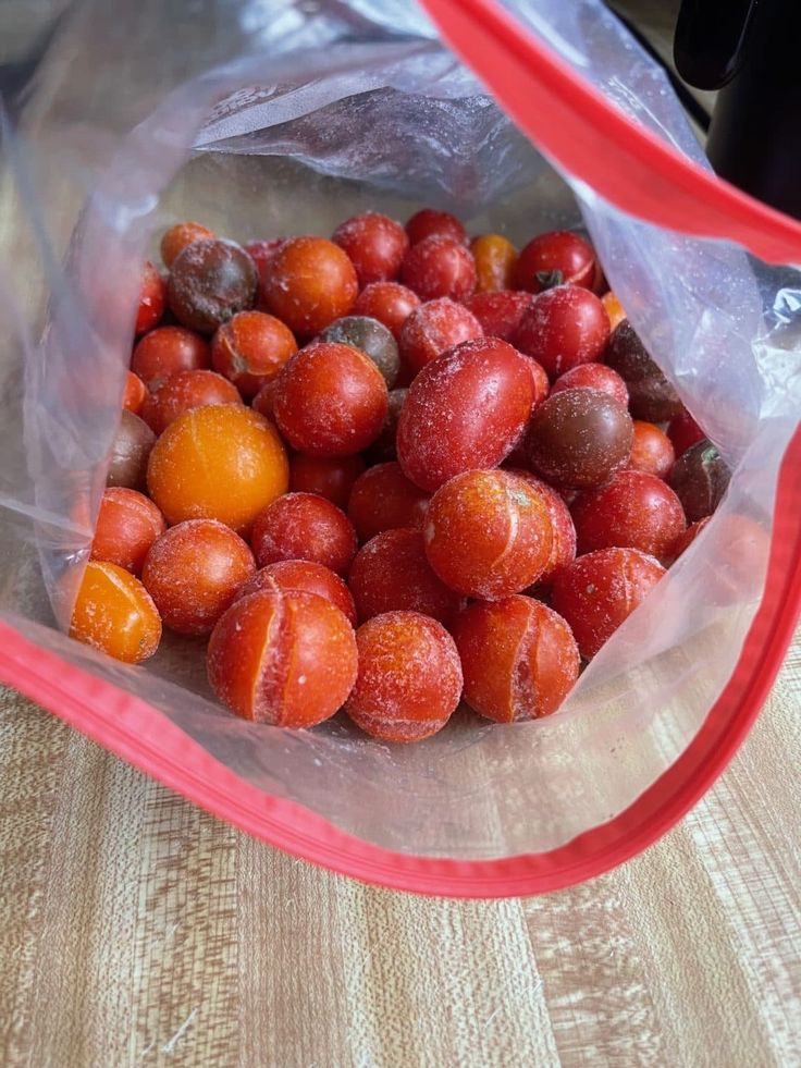 a plastic bag filled with fruit sitting on top of a wooden table