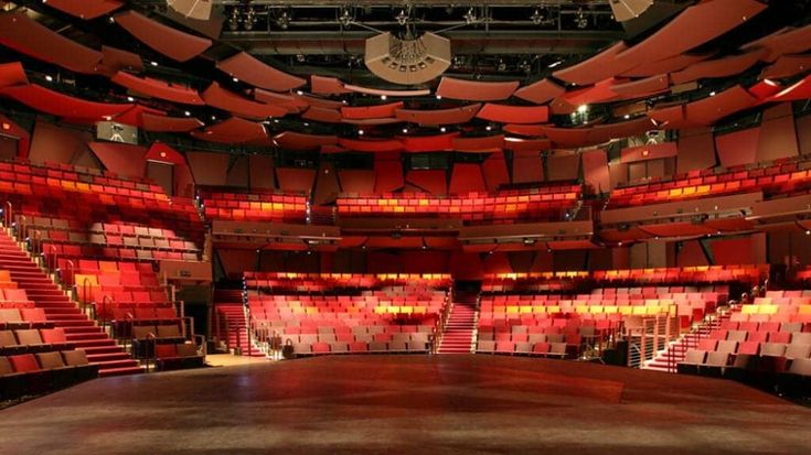 an empty auditorium with red seats and lights