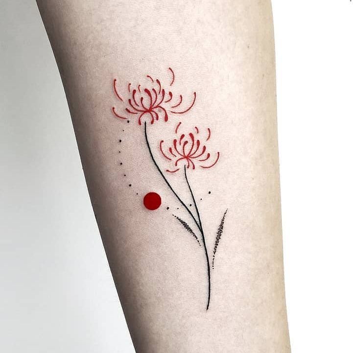 a woman's arm with red ink and flowers on the left side of her body