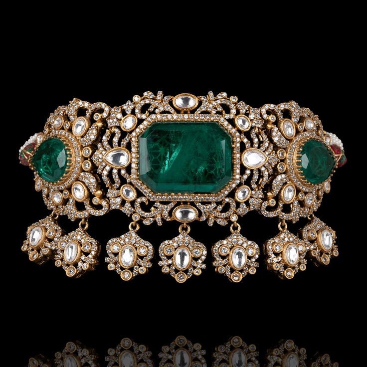 Indulge in luxury, embrace elegance and experience the allure of Kanwal Set - where every piece tells a story of timeless beauty and unparalleled craftsmanship! Dazzle and delight with every step wearing our breathtaking jewelry set featuring a mesmerizing combination of CZ stones with its unparalleled brilliance, polished emeralds evoking the lush beauty of a verdant paradise, and exquisite jadau kundan stones. The set includes a choker and a pair of beautiful earrings. Approximate length of th Luxury Cubic Zirconia Jewelry Sets For Festive Occasion, Opulent Gemstone Jewelry For Anniversary, Elegant Bridal Sets With Diamond Accents, Luxury Kundan Jewelry, Luxury Jewelry Set With Intricate Design For Festive Occasions, Luxury Bridal Necklace With Elegant Design For Formal Events, Luxury Emerald Bridal Necklace For Anniversary, Elegant Emerald Bridal Necklace For Formal Occasions, Luxury Hand-set Jewelry For Festive Occasions