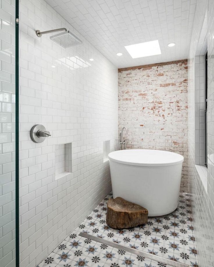 a white bath tub sitting in a bathroom next to a wooden block on the floor