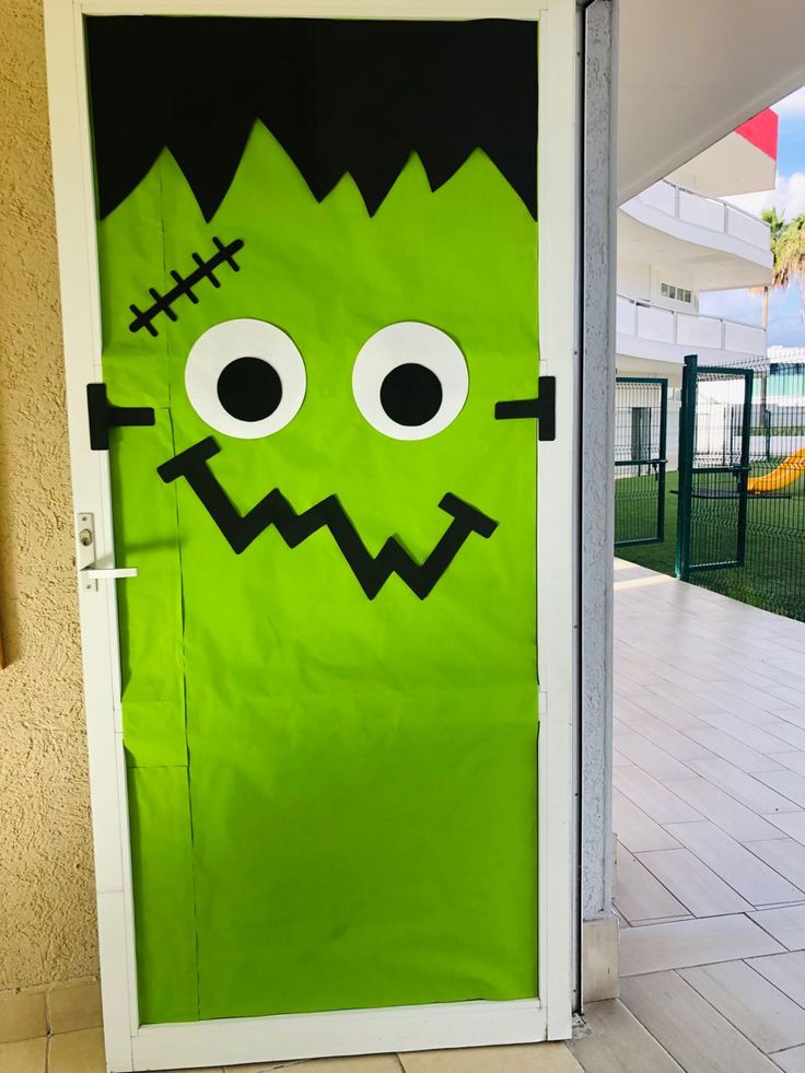 a green door decorated to look like a monster