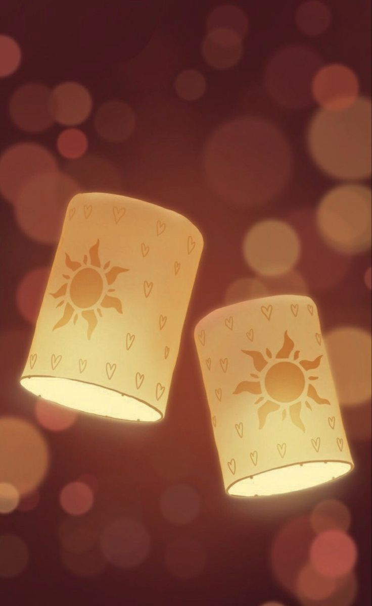 two yellow lamps with hearts and sun designs on them are shining brightly in the dark