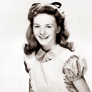 an old black and white photo of a woman smiling