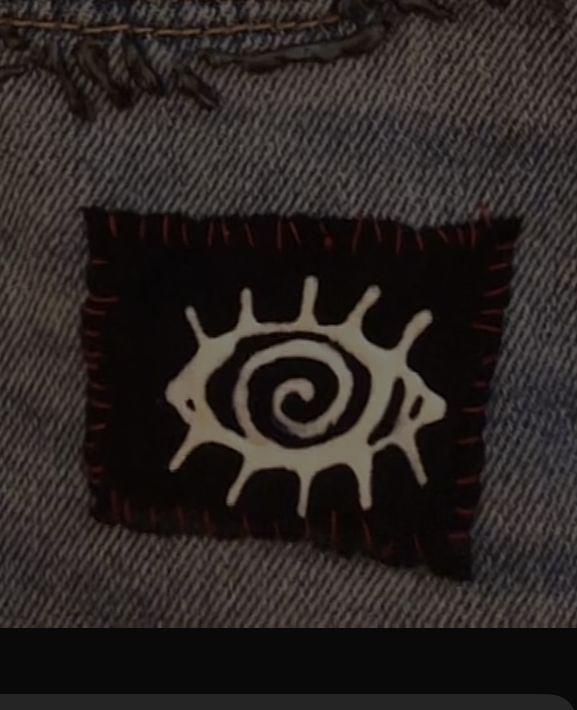 the back pocket of a pair of jeans with an image of a sun on it