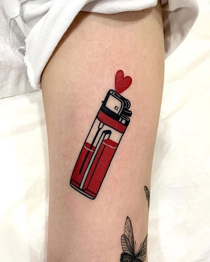 a woman's leg with a red lighter tattoo on her left thigh and a heart in the middle