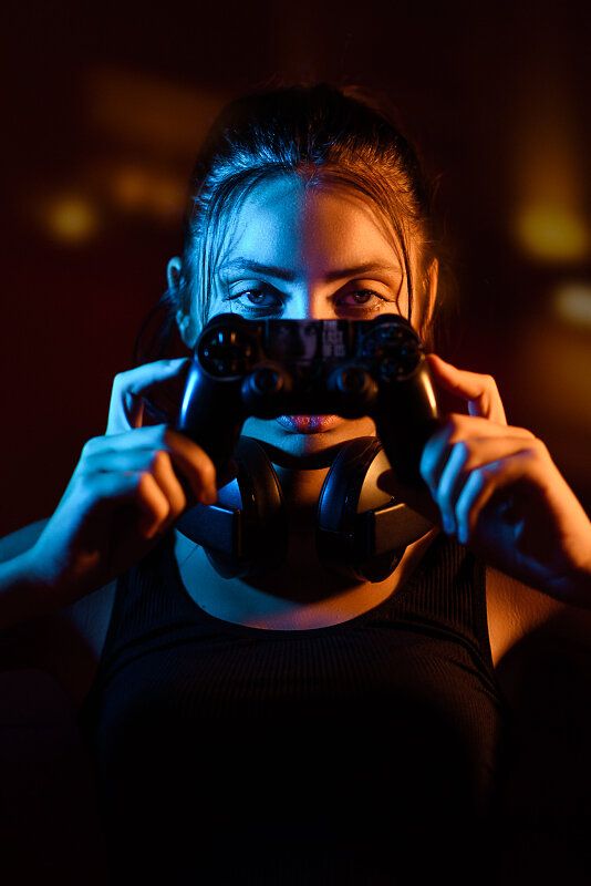 a woman holding a video game controller in front of her face