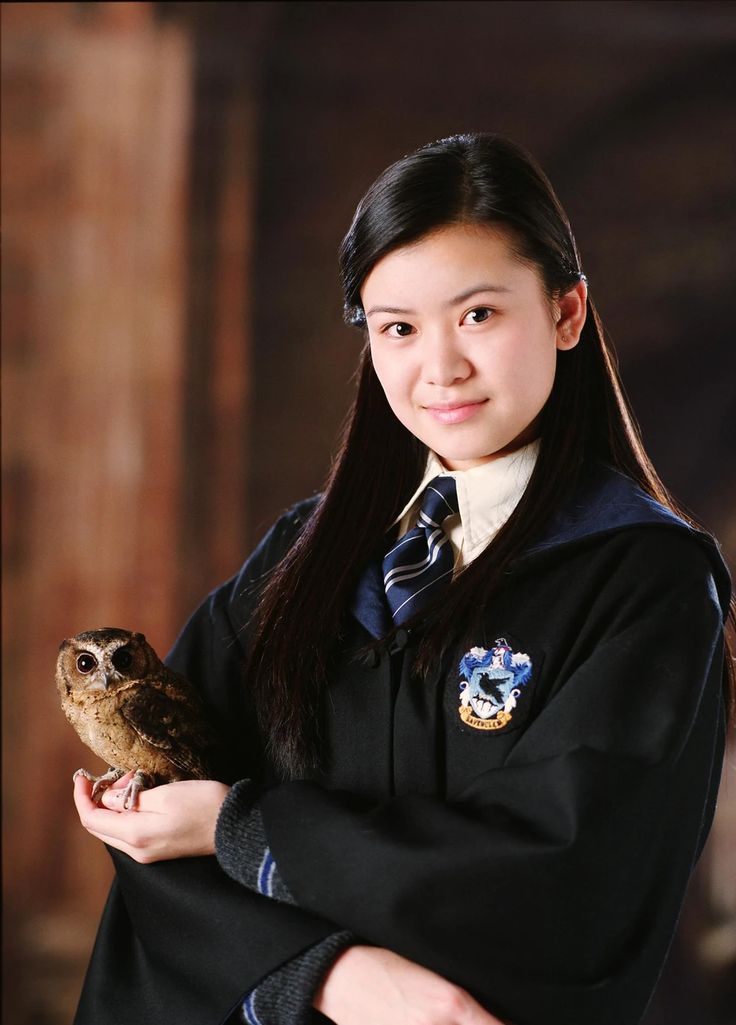 a woman in a harry potter costume holding an owl