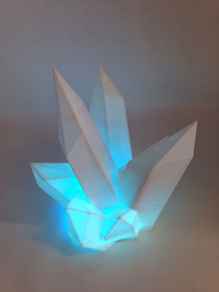 an origami paper sculpture with blue light coming out of it's center