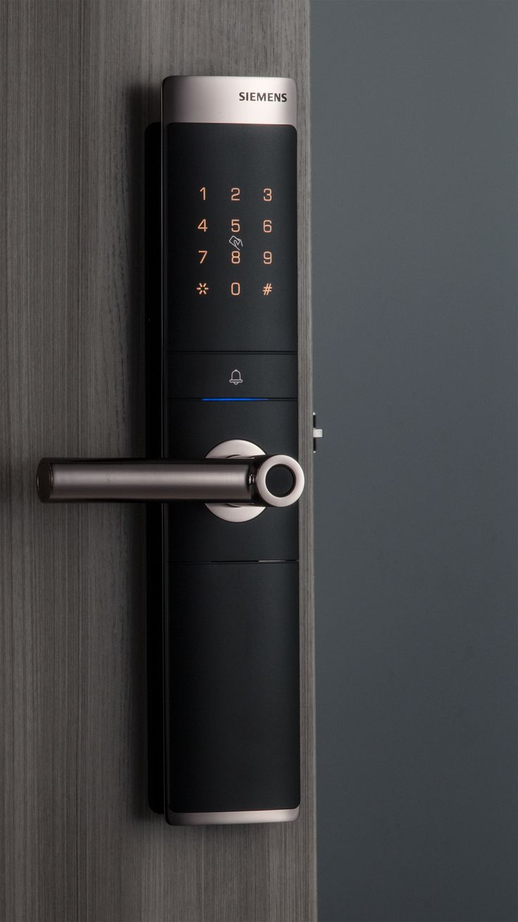 an electronic door lock on a wooden door with the keypad and fingerprints