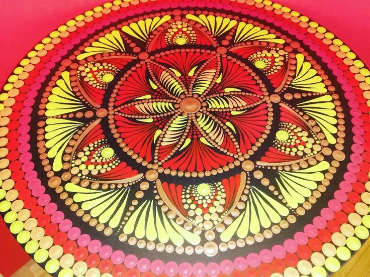 an artistically designed table top in red, yellow and pink with circles around it