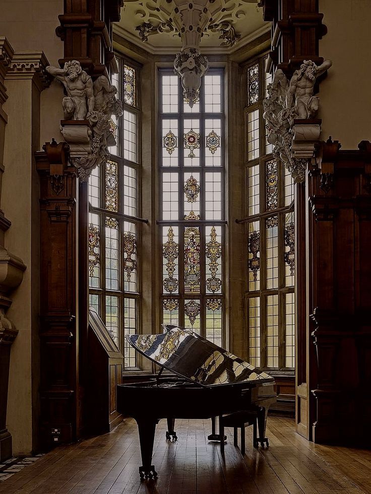 a grand piano sitting in front of a large window