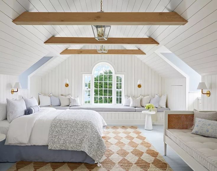 a bedroom with a bed, couch and window in the ceiling is decorated in white wood