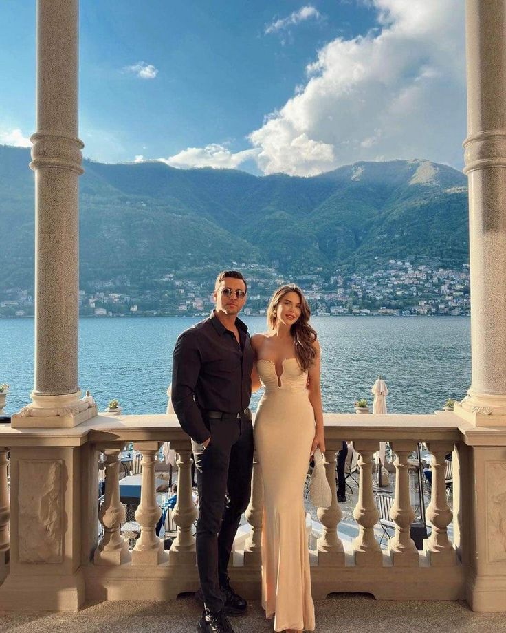 a man and woman standing next to each other on a balcony