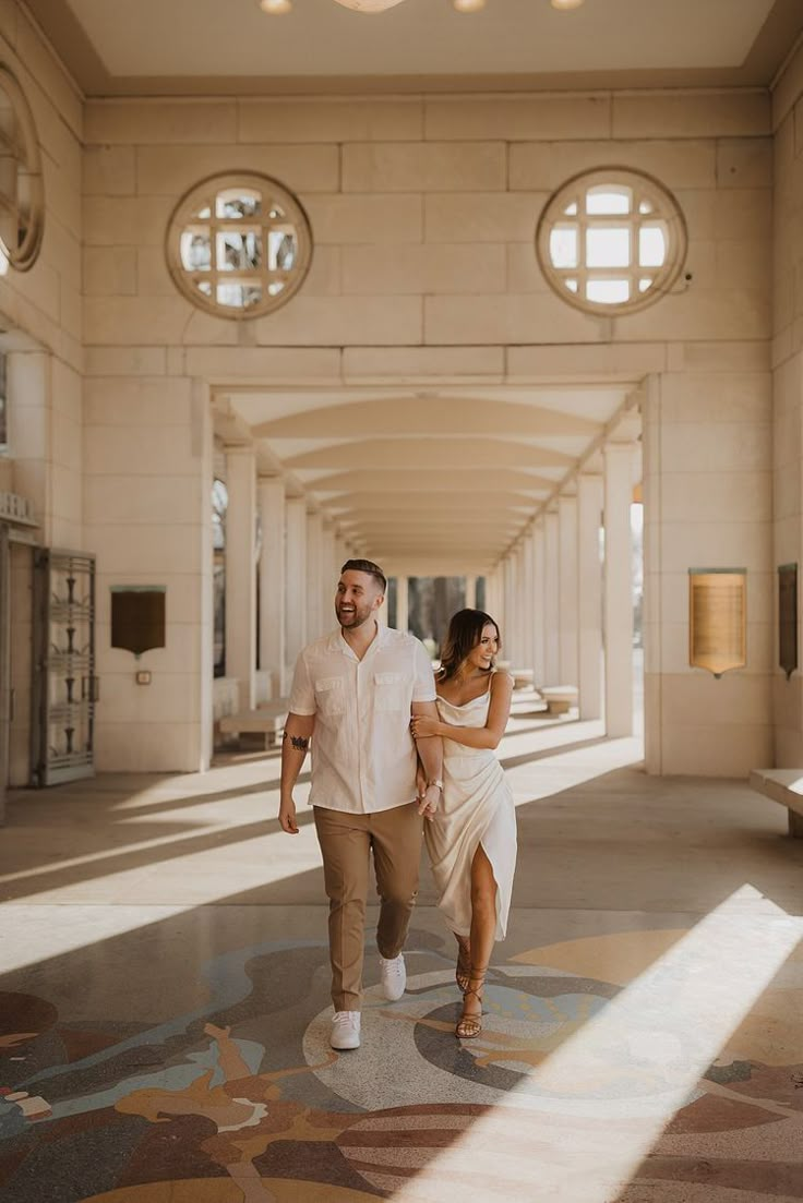 a man and woman are walking through an empty building