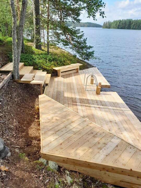 a wooden dock sitting on the side of a lake